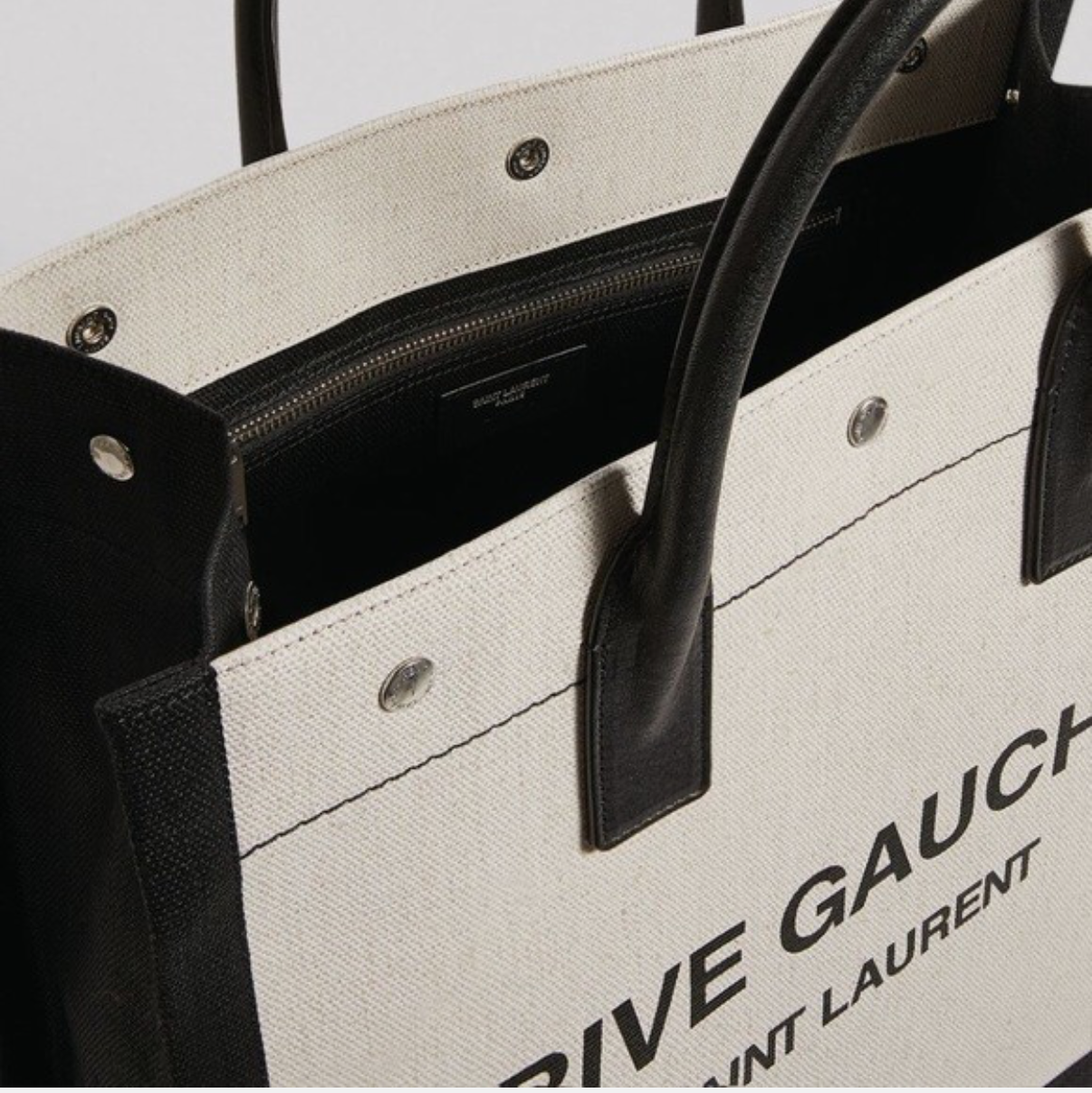 Close-up of a Yves Saint Laurent tote bag with black handles on eBay.