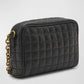 Black quilted handbag with a gold chain on a light gray background