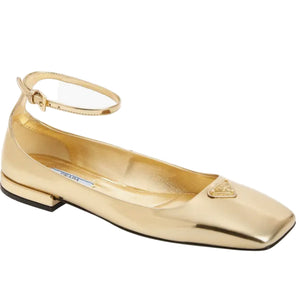 Gold flat shoe with a brand logo on a white background