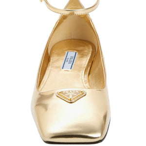 Gold high-heeled shoe with Prada logo on a white background