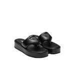 Black sandals with a brand logo on a light gray background