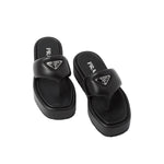 Pair of black Prada sandals on a light gray background