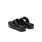 Black sandals with a brand logo on a light gray background