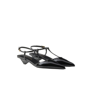 Black pointed-toe shoes with thin straps on a white background