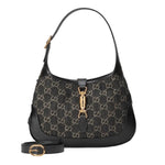 Black handbag with gold accents on a light gray background