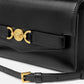 Black handbag with gold accents on a white background