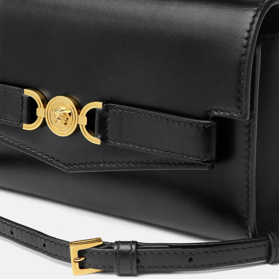 Black handbag with gold accents on a white background