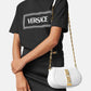 Person wearing a black Versace t-shirt with a white handbag featuring gold chain details.