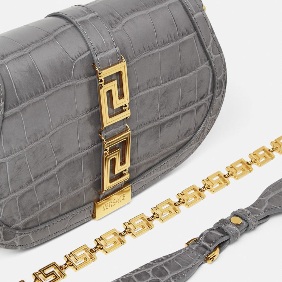 Gray handbag with gold accents on a white background