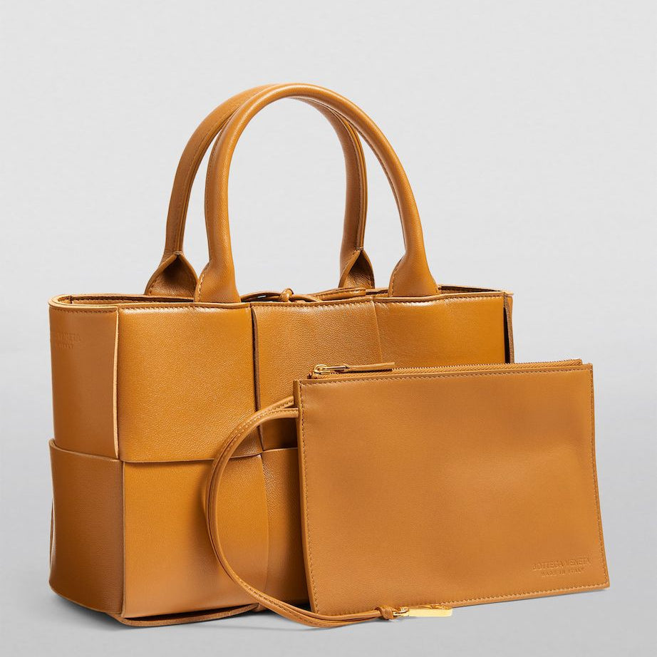 Brown handbag with matching pouch on a light gray background