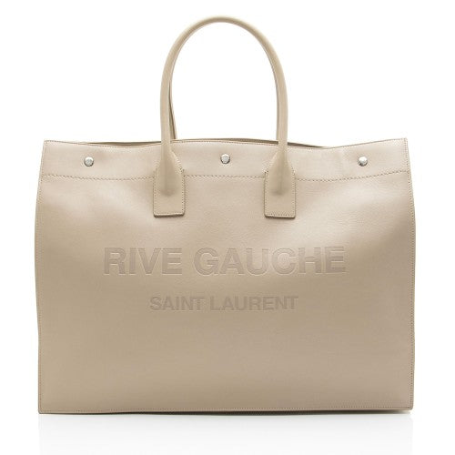 Beige handbag with 'Rive Gauche Saint Laurent' branding on a white background