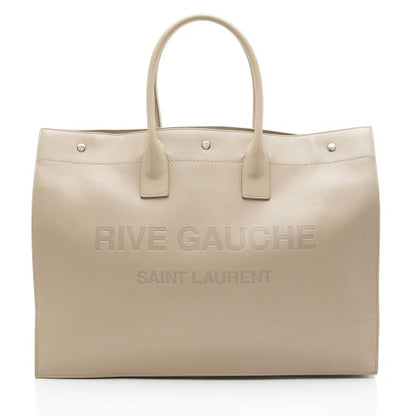 Beige handbag with 'Rive Gauche Saint Laurent' branding on a white background