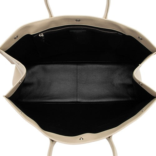 Beige handbag with black interior on a white background