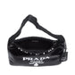 Black Prada handbag with studded details on a white background