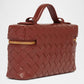 Brown woven handbag with a gold zipper on a white background