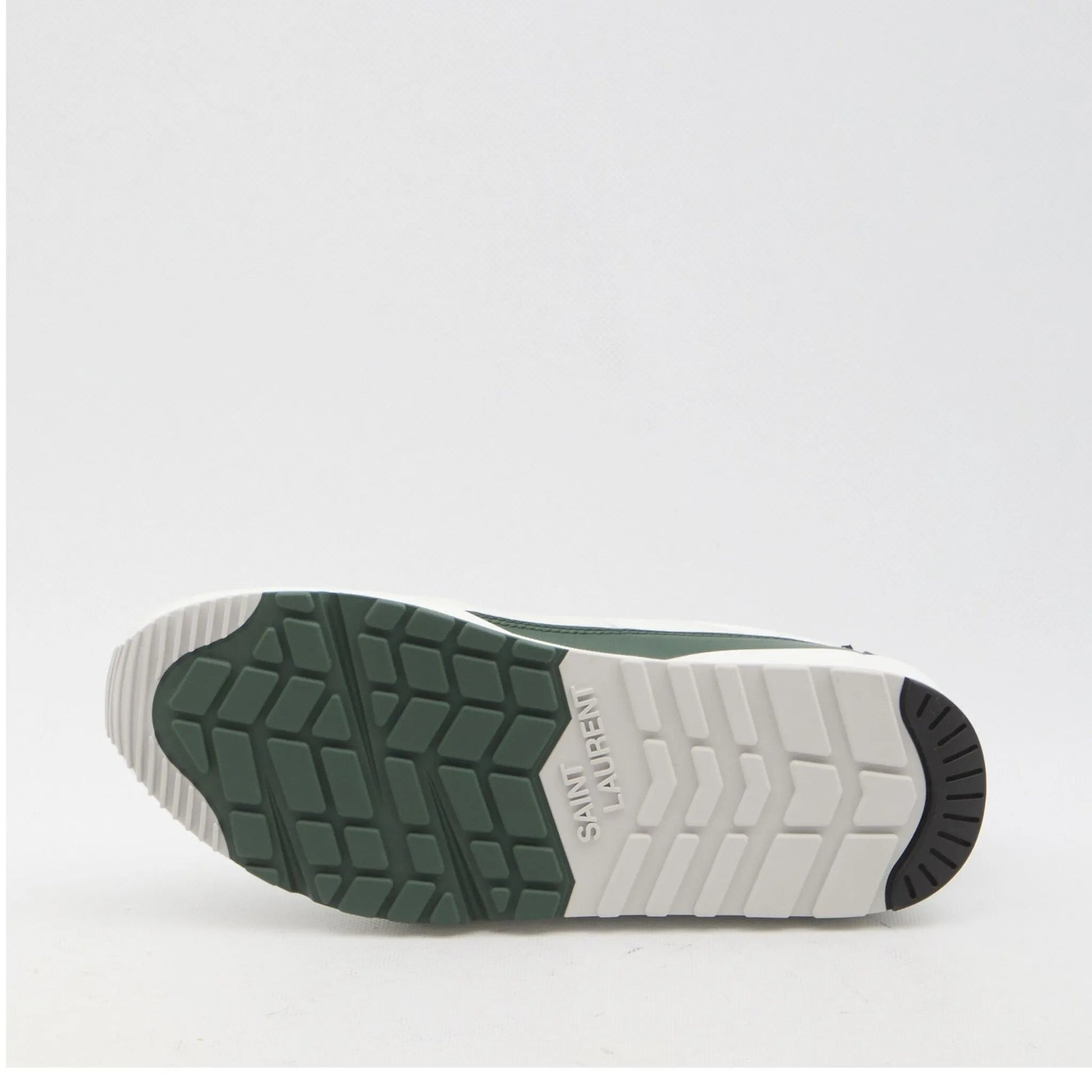 Green sneaker with white sole on a light gray background