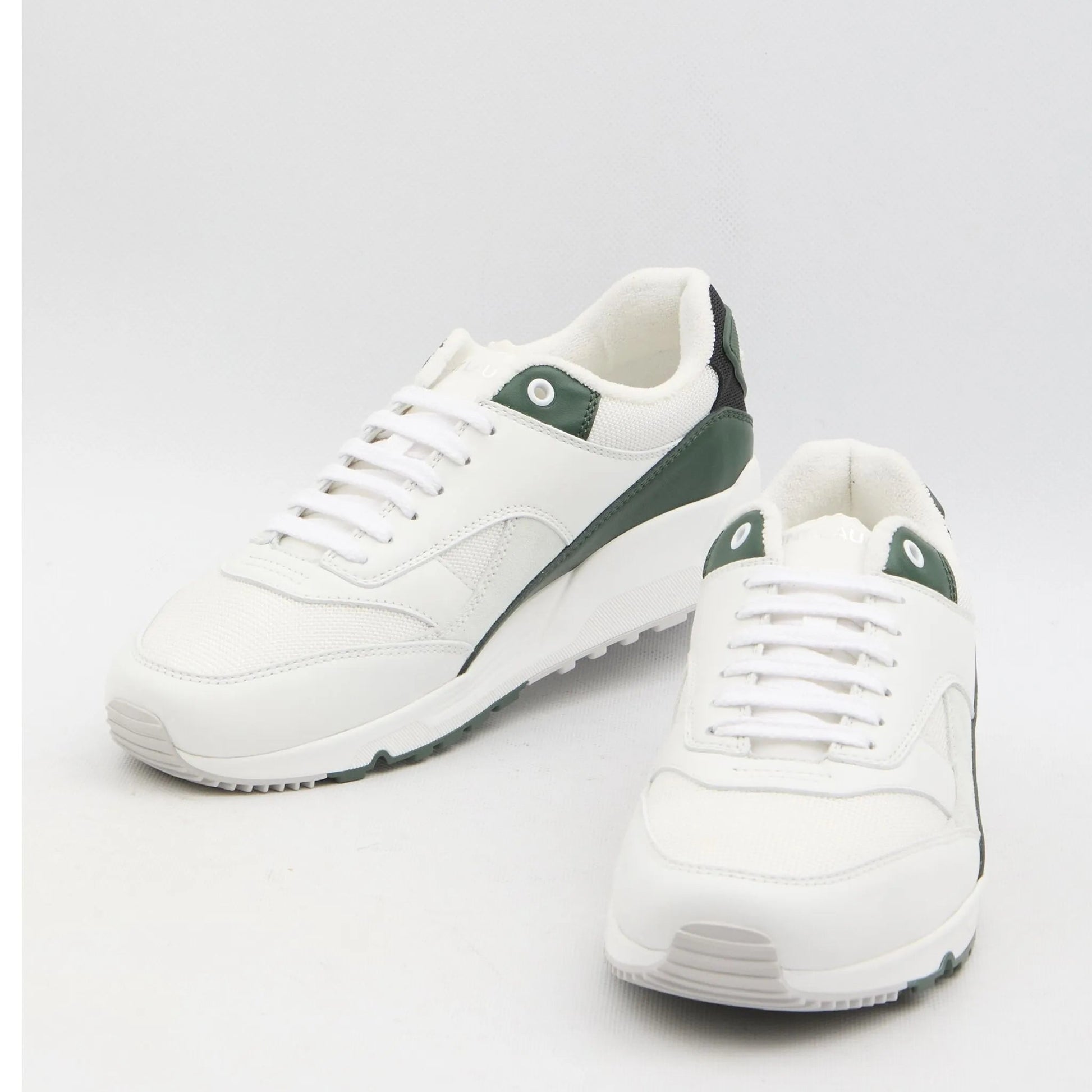 White sneakers with green accents on a light gray background