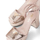 Pair of gold high-heeled Prada shoes with glittery platform and decorative elements on a white background