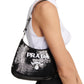 Black Prada handbag with sequins held by a person on a white background