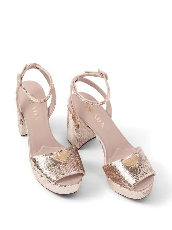 Pair of pink high-heeled sandals with sequin details on a white background
