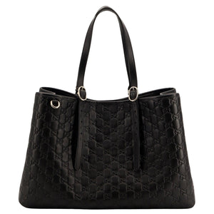 Black quilted handbag on a light gray background