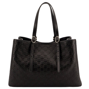 Black quilted handbag on a white background