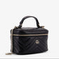 Black quilted handbag with a chain detail on a white background