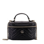 Black quilted handbag with gold chain and logo on a white background