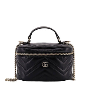 Black quilted handbag with gold chain and logo on a white background