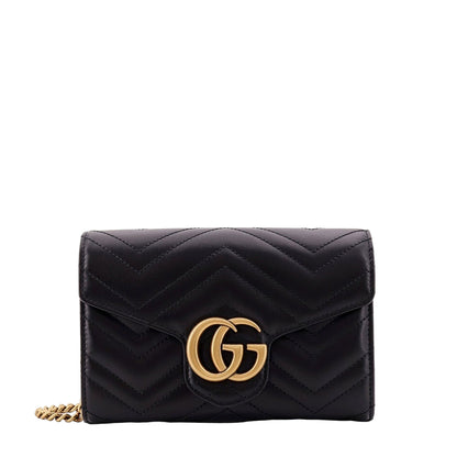 Black quilted handbag with gold chain and logo on a white background