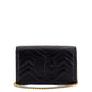 Black quilted handbag with gold chain on a white background