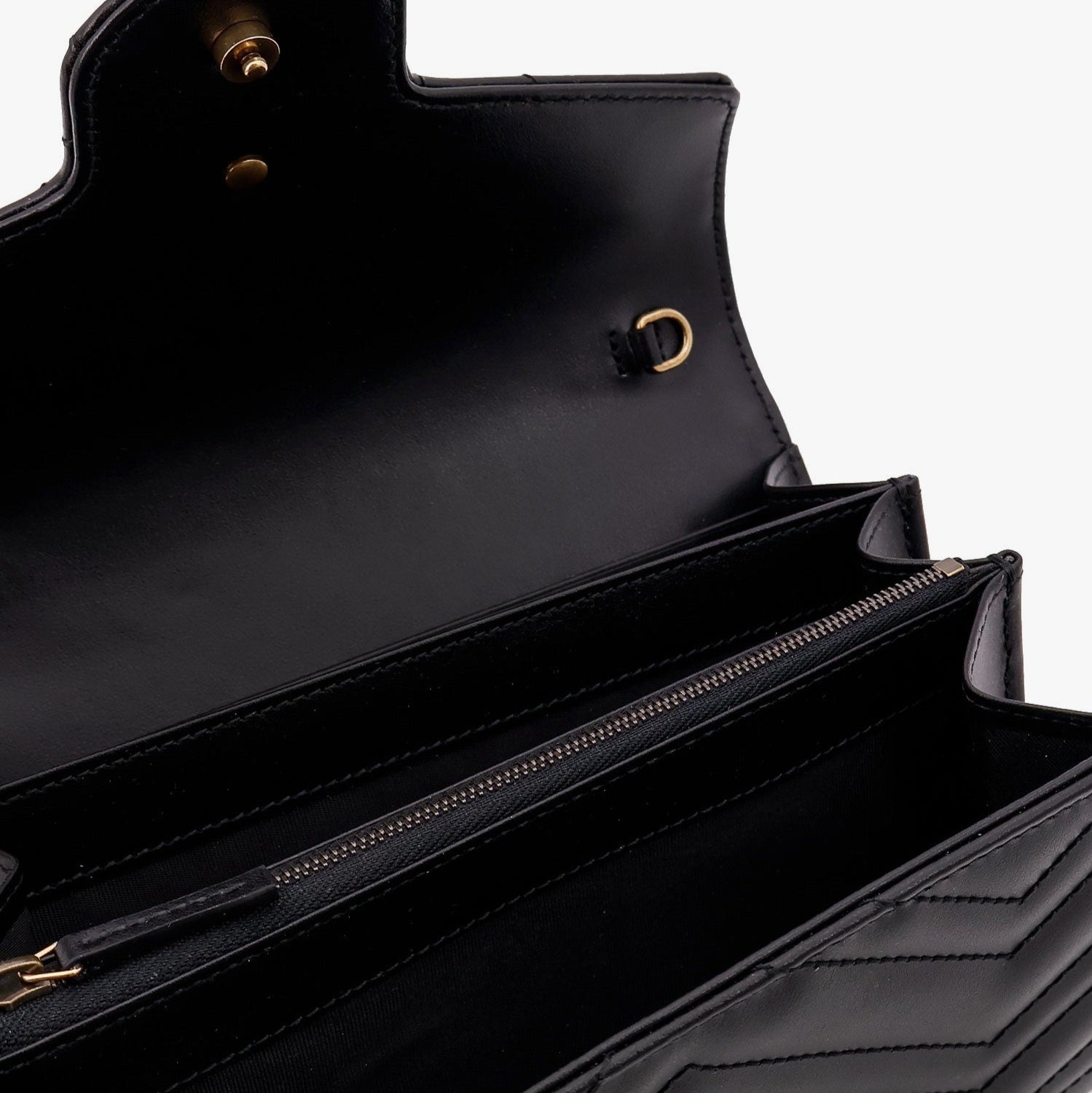 Black leather bag with gold hardware on a white background
