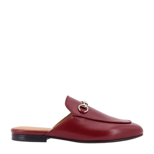 Red loafer shoe with a gold buckle on a white background
